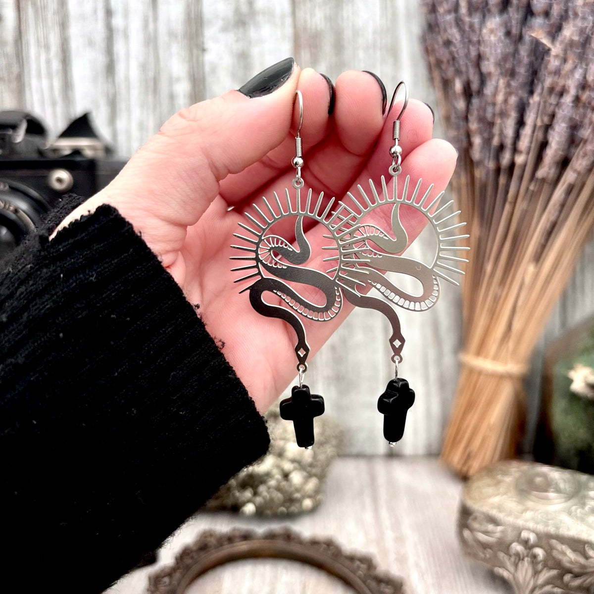 Stainless steel snake and black cross dangle earrings by FOXLARK, featuring intricate designs and long, stylish earring hooks.
