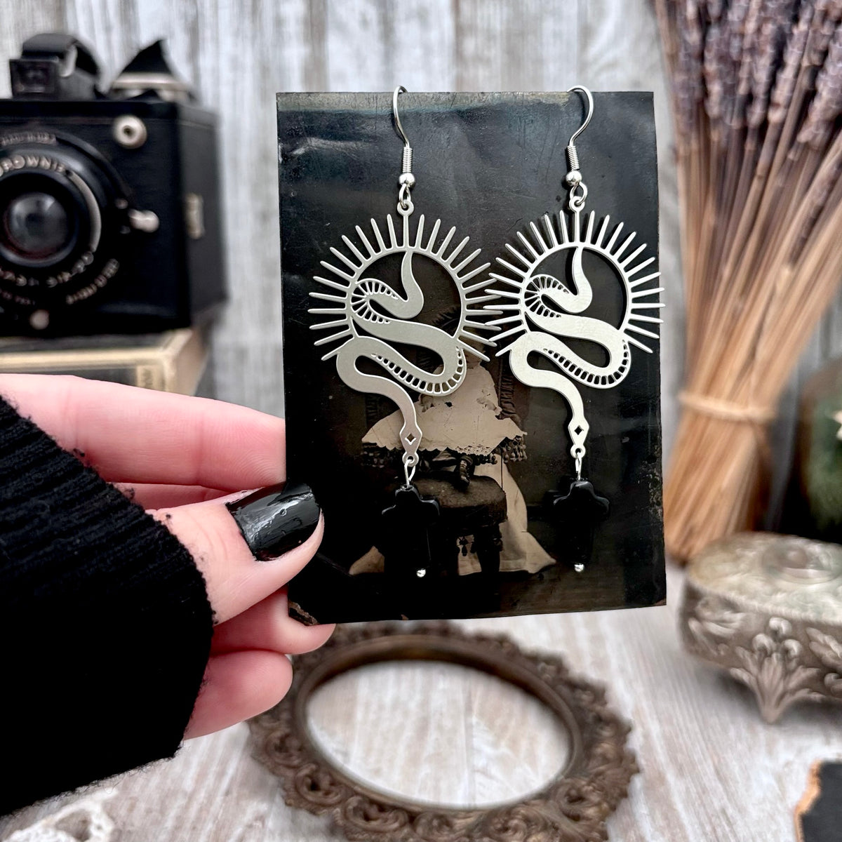 Stainless steel snake and black cross dangle earrings by FOXLARK with long, intricate design and hanging details.