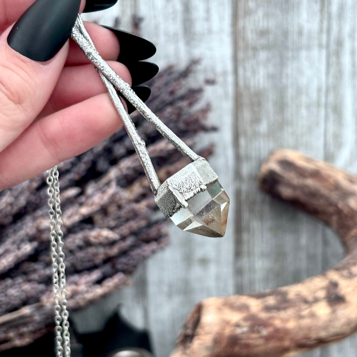 Silver quartz crystal necklace from FOXLARK's Sticks & Stones collection, featuring a polished quartz pendant on a silver chain.