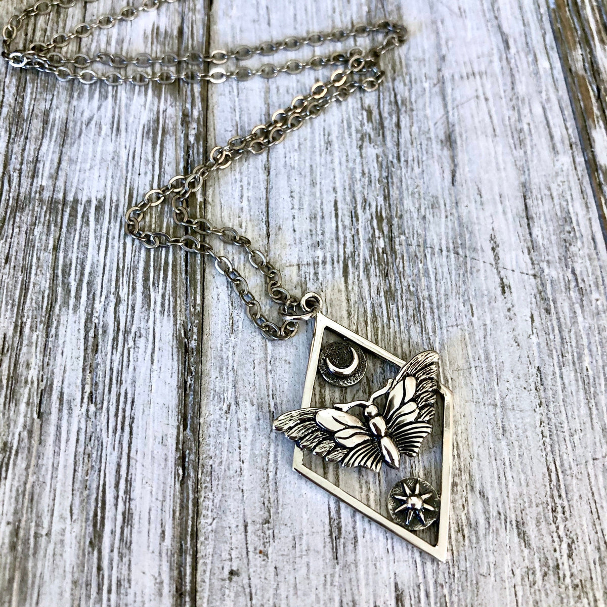 Sterling silver geometric moth necklace with sun and moon design from FOXLARK Tiny Talisman Collection, 32x21mm.