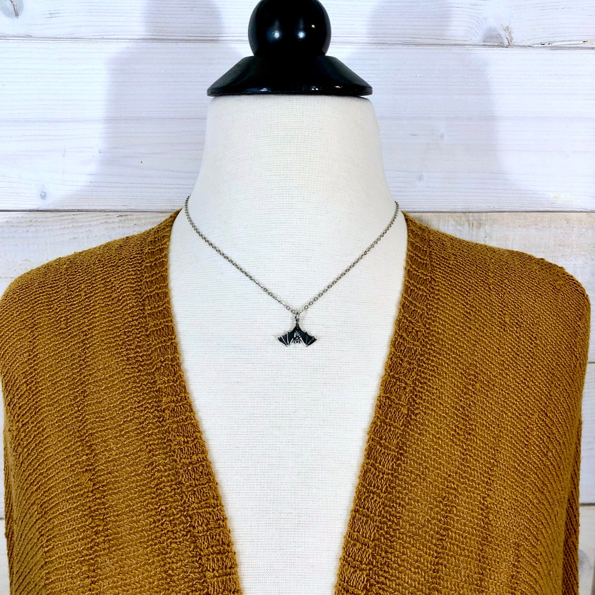 Sterling silver tiny bat pendant from FOXLARK's TINY TALISMANS collection, measuring 12x20mm, displayed on a chain.