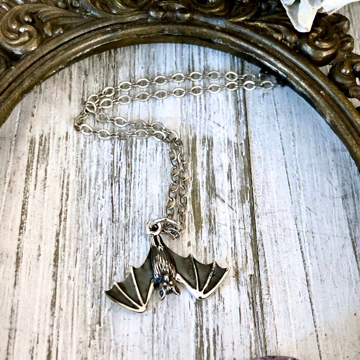Sterling silver tiny bat necklace pendant from the FOXLARK Tiny Talisman Collection, 12x20mm, featuring a detailed bat design.