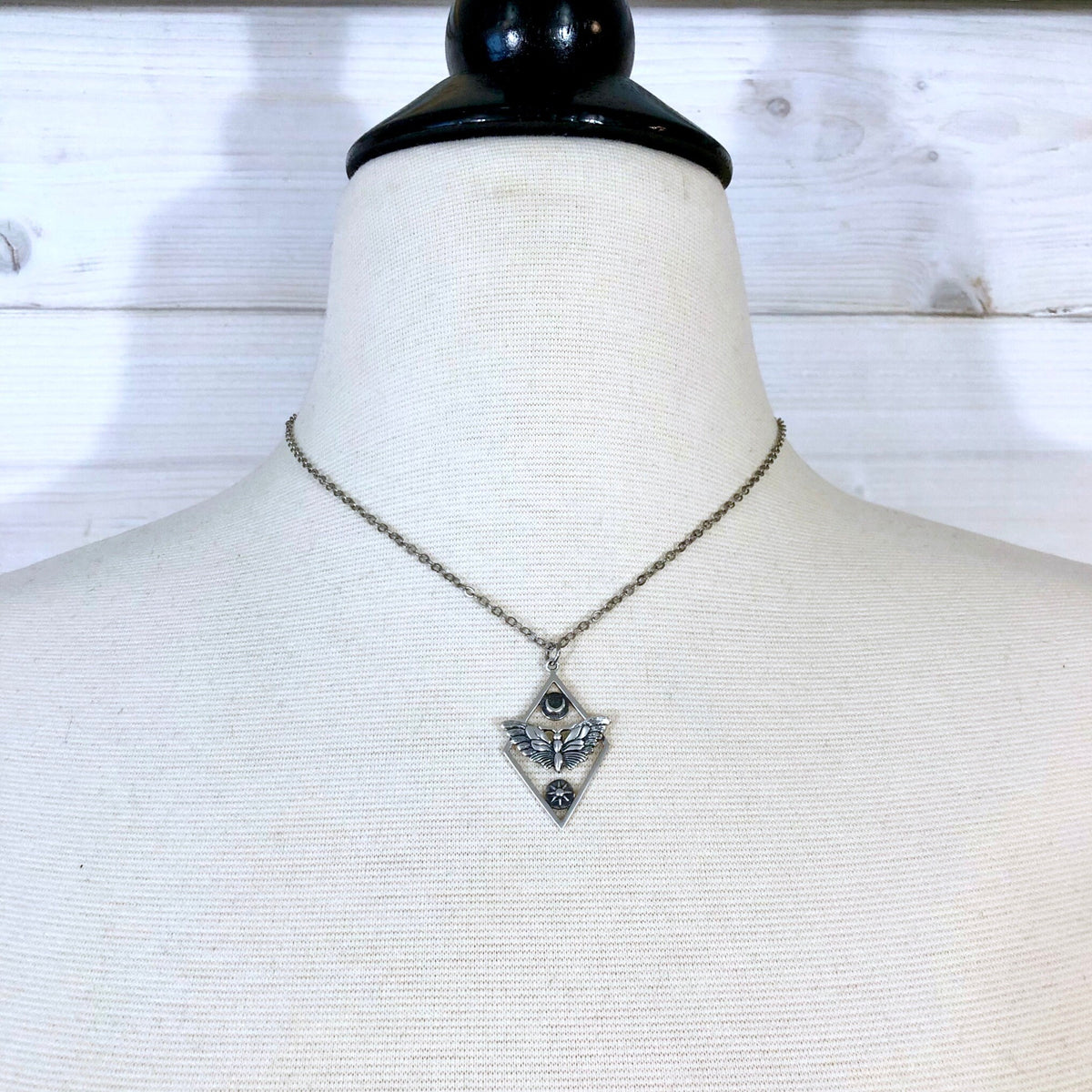 Sterling silver geometric moth necklace with sun and moon charms from FOXLARK Tiny Talisman Collection, 32x21mm.