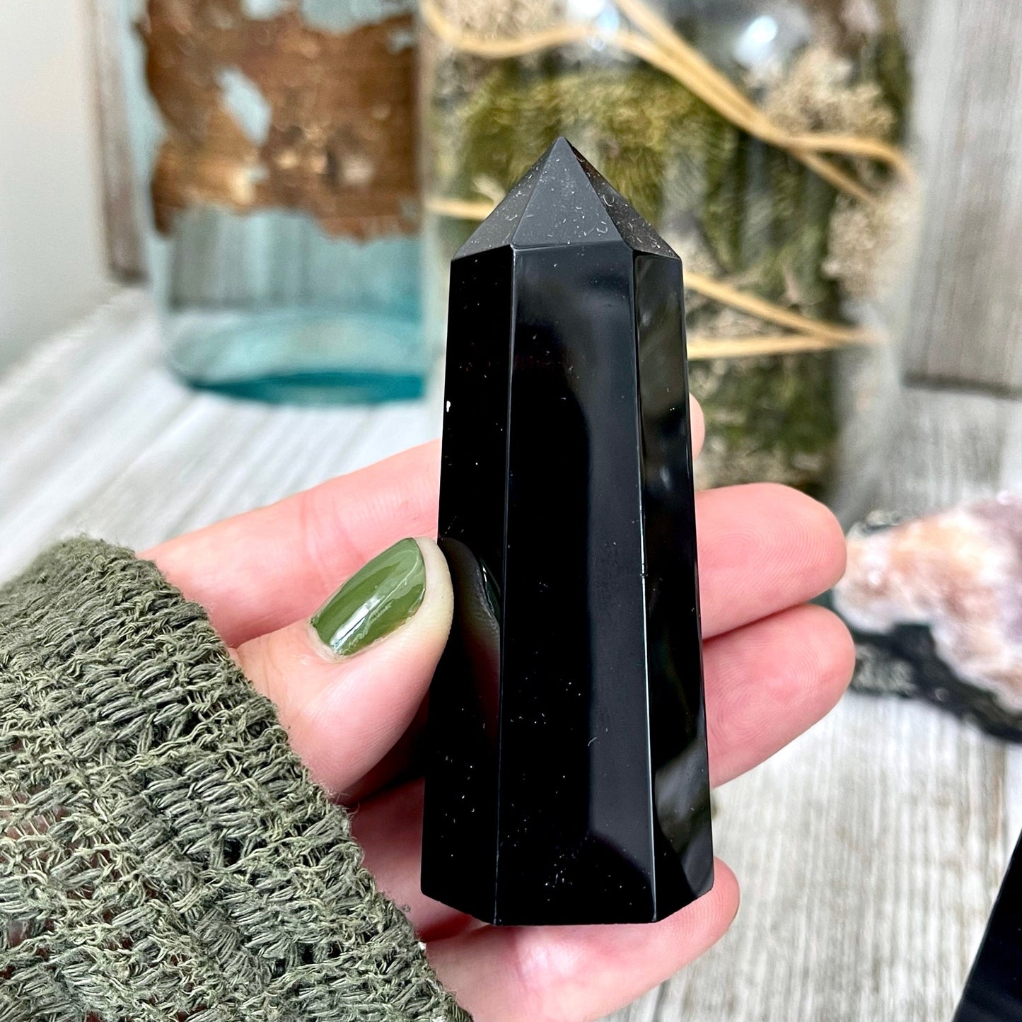 Self-standing black obsidian point from FoxlarkCrystals, showcasing a sleek, polished crystal with natural striations and sharp tips.