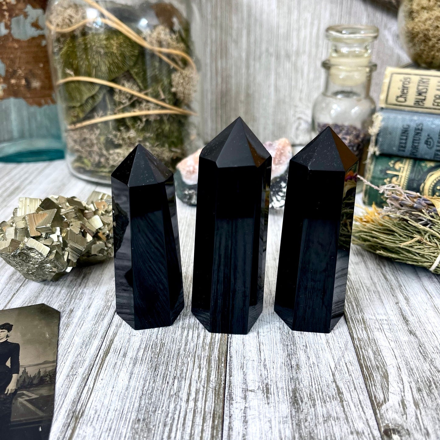 Self-standing black obsidian crystal point from FoxlarkCrystals, showcasing a sleek, polished black stone with sharp geometric edges.