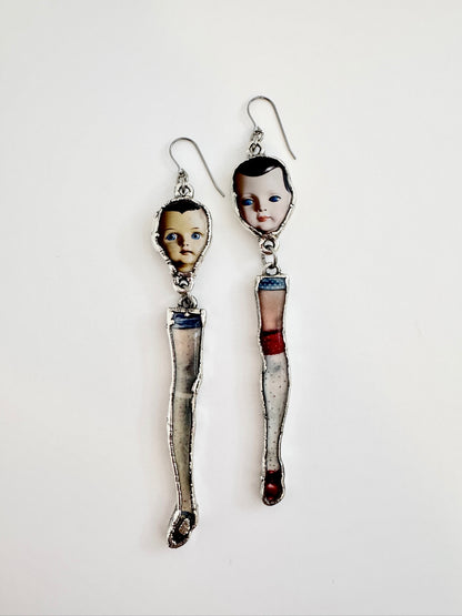 Silver mismatched doll head and leg earrings with long dangle design, statement jewelry from FOXLARK's The Weirdlings Collection.
