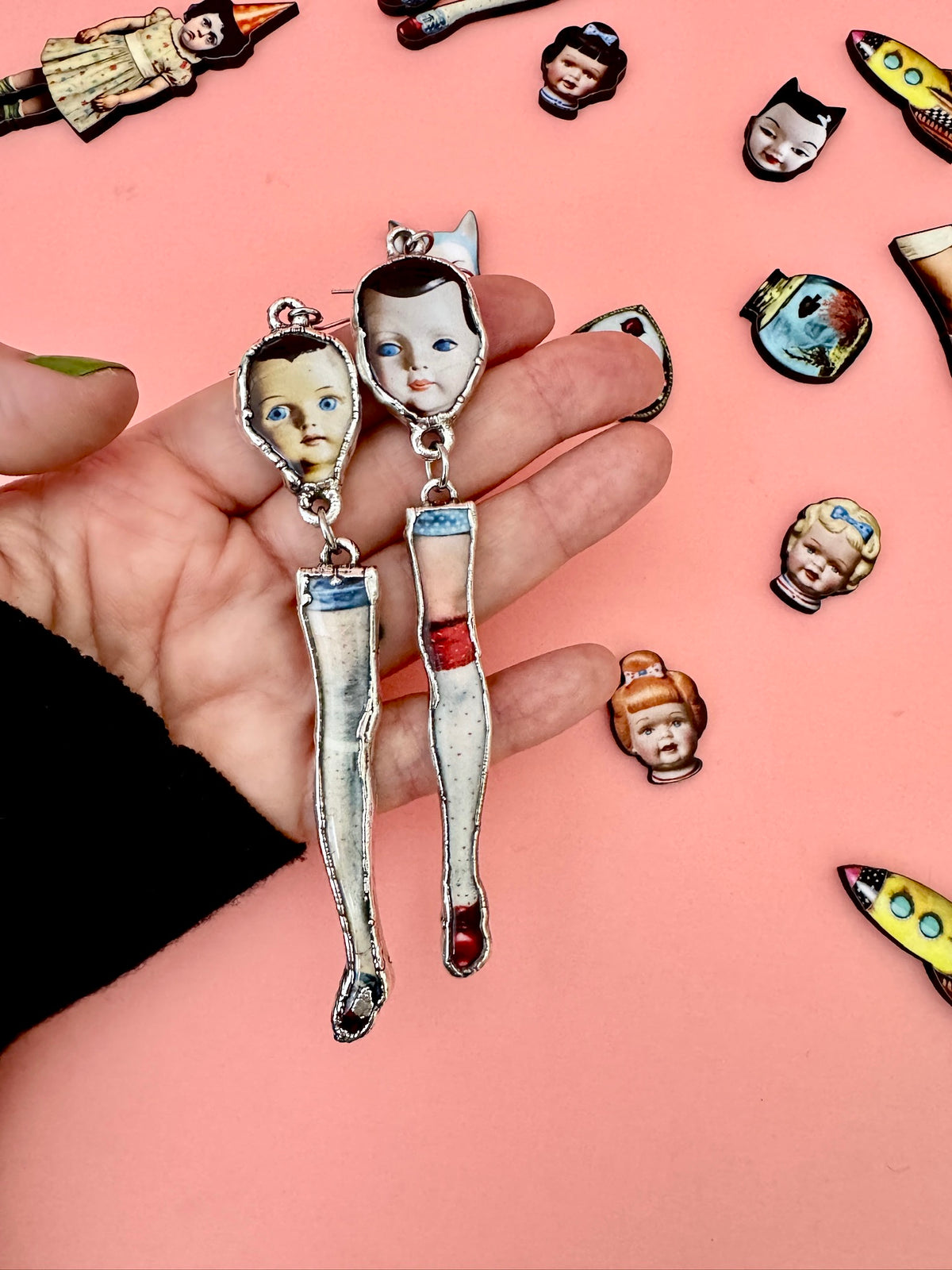 Silver mismatched doll head and leg earrings with long dangle design from FOXLARK's The Weirdlings Collection.