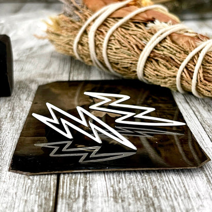 Sterling silver lightning bolt stud earrings by FOXLARK, close-up of sleek, minimalist lightning bolt design in shiny silver.